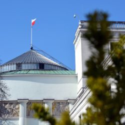 Budynek sejmu z powiewającą flagą Polski